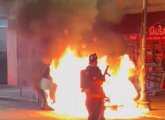 Firefighter in front of flaming car