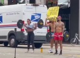 Three people in Goverment Center offering to lift weights for every honk