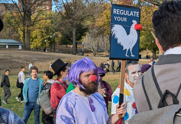 Man with sign telling the forced birthers to regulate their male chickens